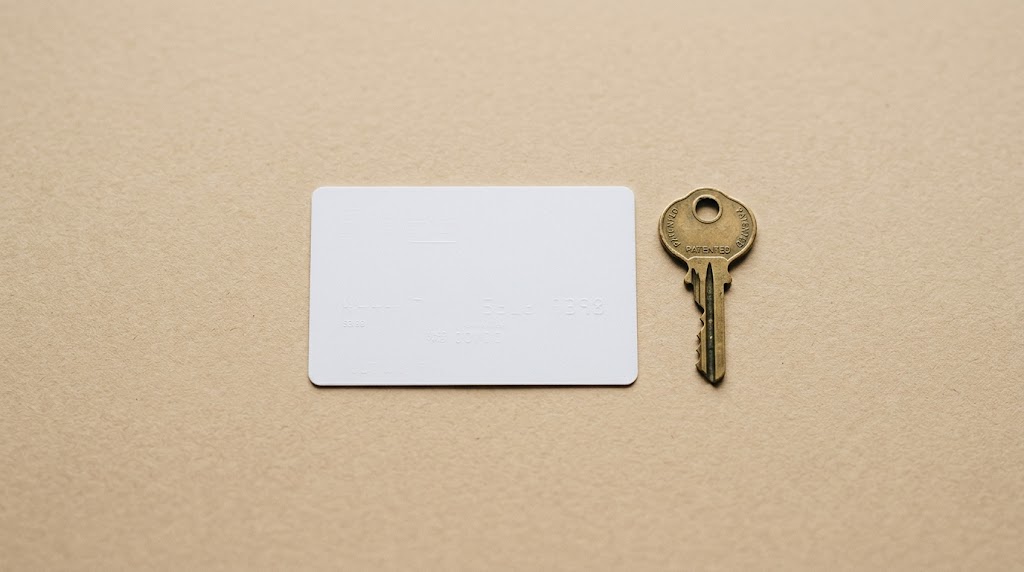 Carte de propriété d'une serrure brevetée posée à côté d'une clé en laiton, sur un bureau en bois clair.
